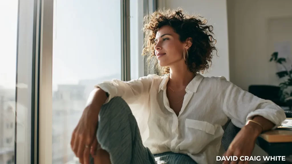 Person sitting calmly by a window, reflecting after a mindset coaching session